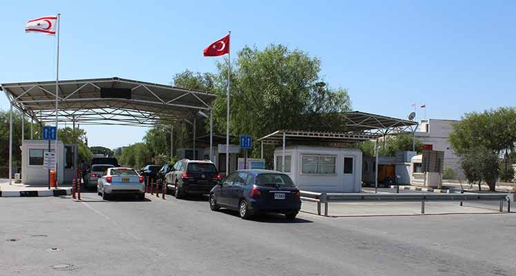 Cars queuing at the Metehan (Agios Dometios) vehicle crossing in Nicosia, under the TRNC and Turkish flags