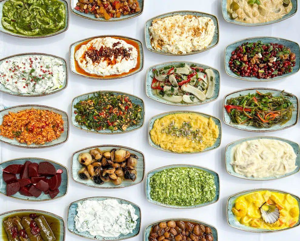 A Cypriot meze spread seen from above — around twenty small plates of dips, olives and vegetables