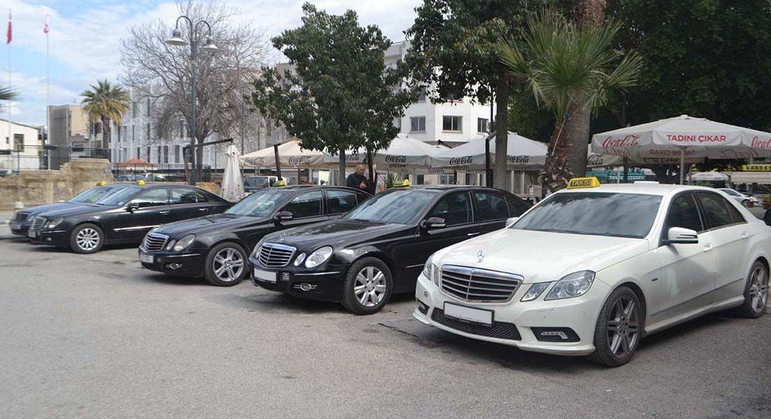 A rank of taxis waiting in a town square in North Cyprus